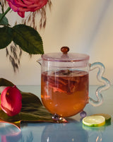 Bloom glass teapot (The Qi x SLJ) featuring floral tea with vibrant colors and elegant design.