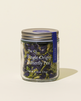 Single Origin Butterfly Pea herbal tea in a glass jar, showcasing vibrant blue-violet dried flowers.