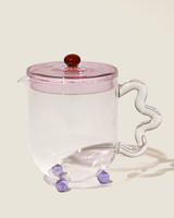 Bloom glass teapot (The Qi x SLJ) featuring a unique design with a pink lid and whimsical handle.
