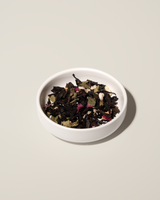 Cleanse Tea blend of organic flowers and herbs in a white bowl for detoxification and wellness.
