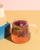 Daily Ritual Set showcasing vibrant flower tea brewed in a clear glass vessel.