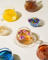 Blooming Tea Ritual Set showcasing colorful blooming teas in elegant glass cups.