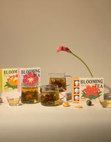 Blooming Tea Ritual Set with flower tea boxes, infused tea glasses, and blooming flowers creating a serene tea experience.