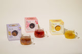 Ultimate Wellness Set featuring colorful tea boxes and brewed tea in clear mugs.