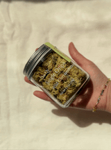 Person holding a jar of Wild Chrysanthemum, showcasing the single origin tea with a floral appearance.