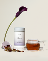 Sleep Tea packaging with brewed tea, herbs, and a flower for relaxation and restful sleep.