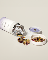 A container of Sleep Tea with a blend of calming herbs spilling out for relaxation and restful sleep.
