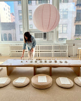 Floral Tea Tasting setup with a long table, tea cups, and a paper lantern in a cozy space.