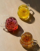 Bulk 30 Pack Flower Teas in glass mugs showcasing colorful flower infusions.