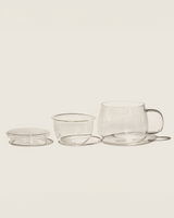 Dewdrop Cup showcasing a clear glass teacup, removable strainer, and lid for blooming teas.