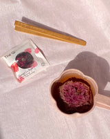 Bamboo Tong next to a floral tea infusion and rose tea bag on soft background, perfect for flower sipping rituals.