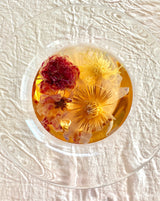 Floral Collection - Variety Box featuring blooming flower tea in a clear dish against a textured white background.
