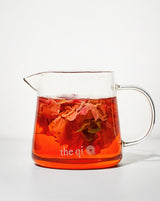Small glass pot filled with rose petals and tea, showcasing minimalist design and quality borosilicate glass.