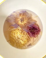 Blooming Tea Ritual Set featuring blooming flower teas in a clear bowl, showcasing vibrant colors and textures.