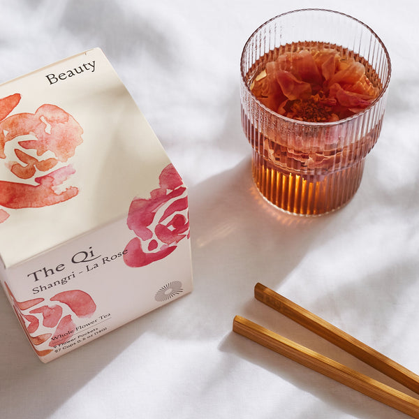 The History and Delightful Journey of Rose Tea with a glass of rose tea and a beautifully designed tea box.