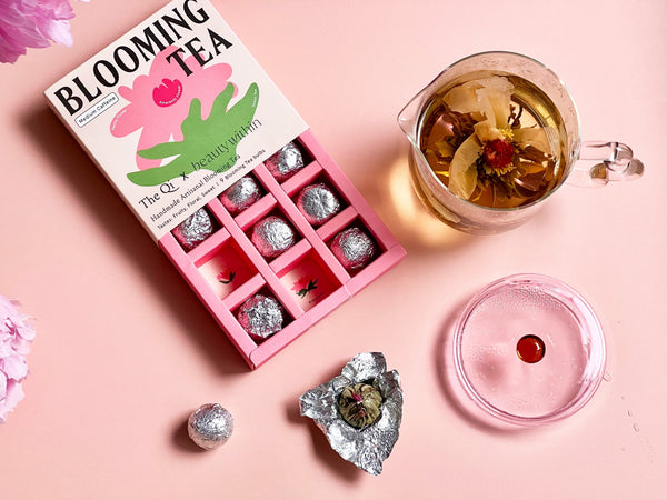 What Is Blooming Tea and Why You Should Drink It - blooming tea box with steeped floral tea in glass pot