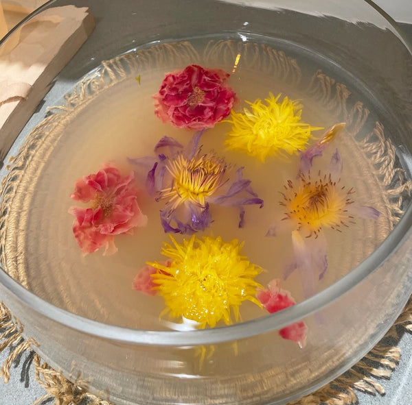 Summer Garden Flower Lemonade with vibrant edible flowers floating in a bowl of lemon-infused water.