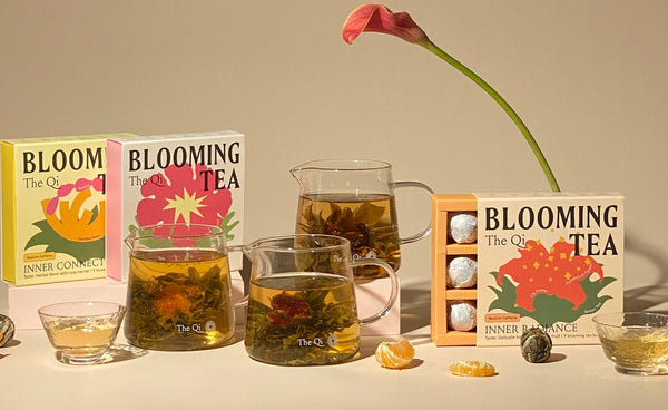 What is Blooming Tea? + Meet Our Varieties with colorful boxes, brewed tea in glass mugs, and floral display.