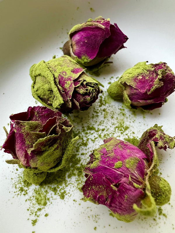 Meet Matcha’s Perfect Pairing with dried roses and matcha powder scattered on a white plate.