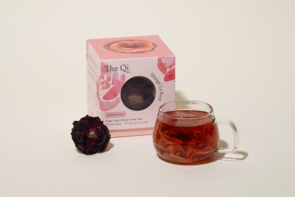 11 Rose tea benefits and history: A cup of rose tea next to a box of rose tea and dried rose bud.