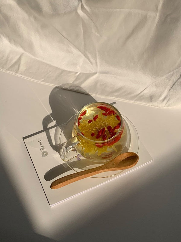 A beautiful cup of flower-infused hot tea on a white background, illustrating the 6 Health Benefits of Hot Tea and History.