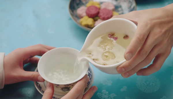 Pouring floral tea into a delicate cup, showcasing the best 8 teas for healthy and glowing skin.