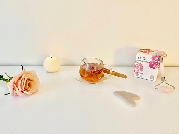 rose with candle, rose tea, and gua sha